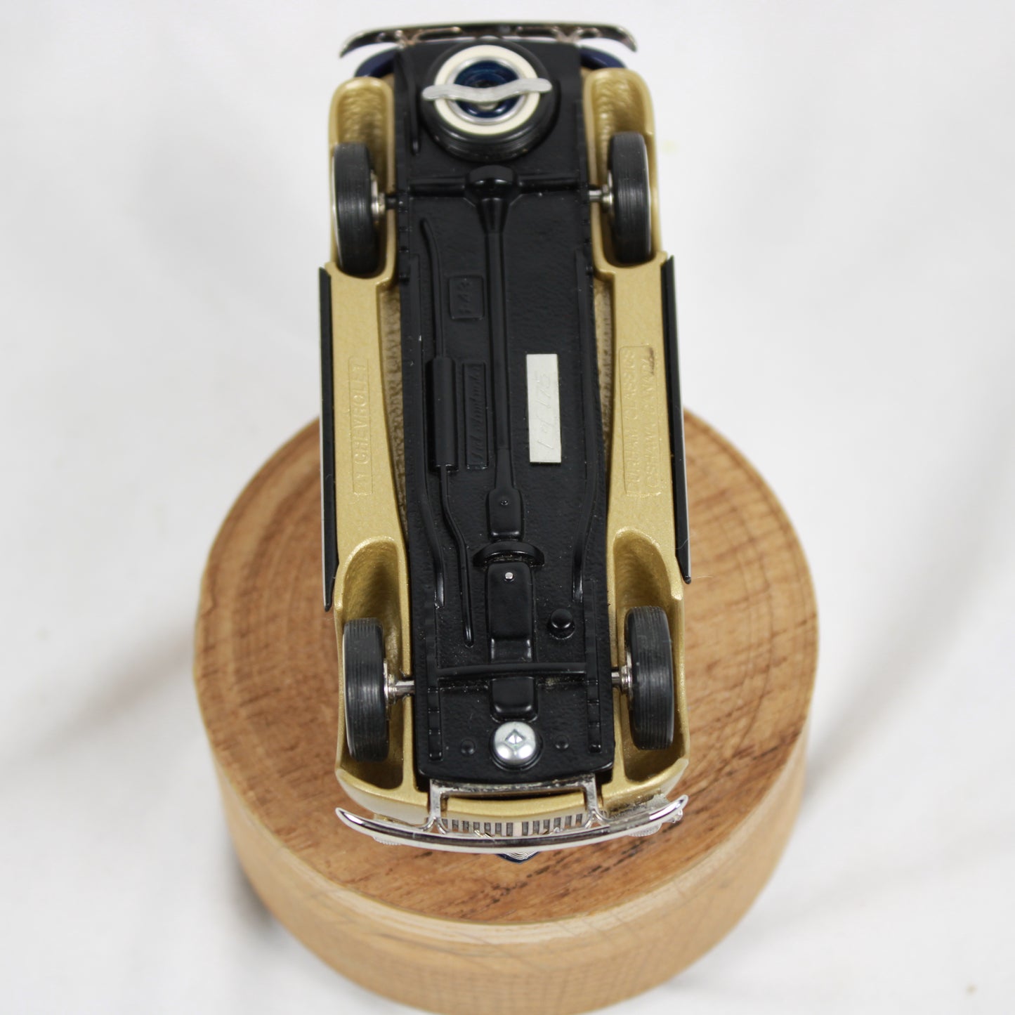Model car on a wooden base with a white background