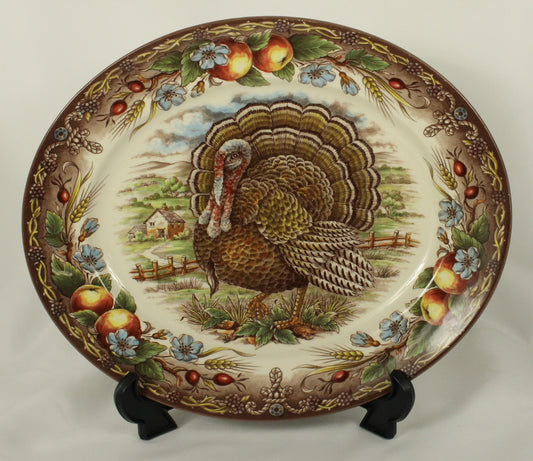 Decorative plate with a turkey design on a stand against a white background
