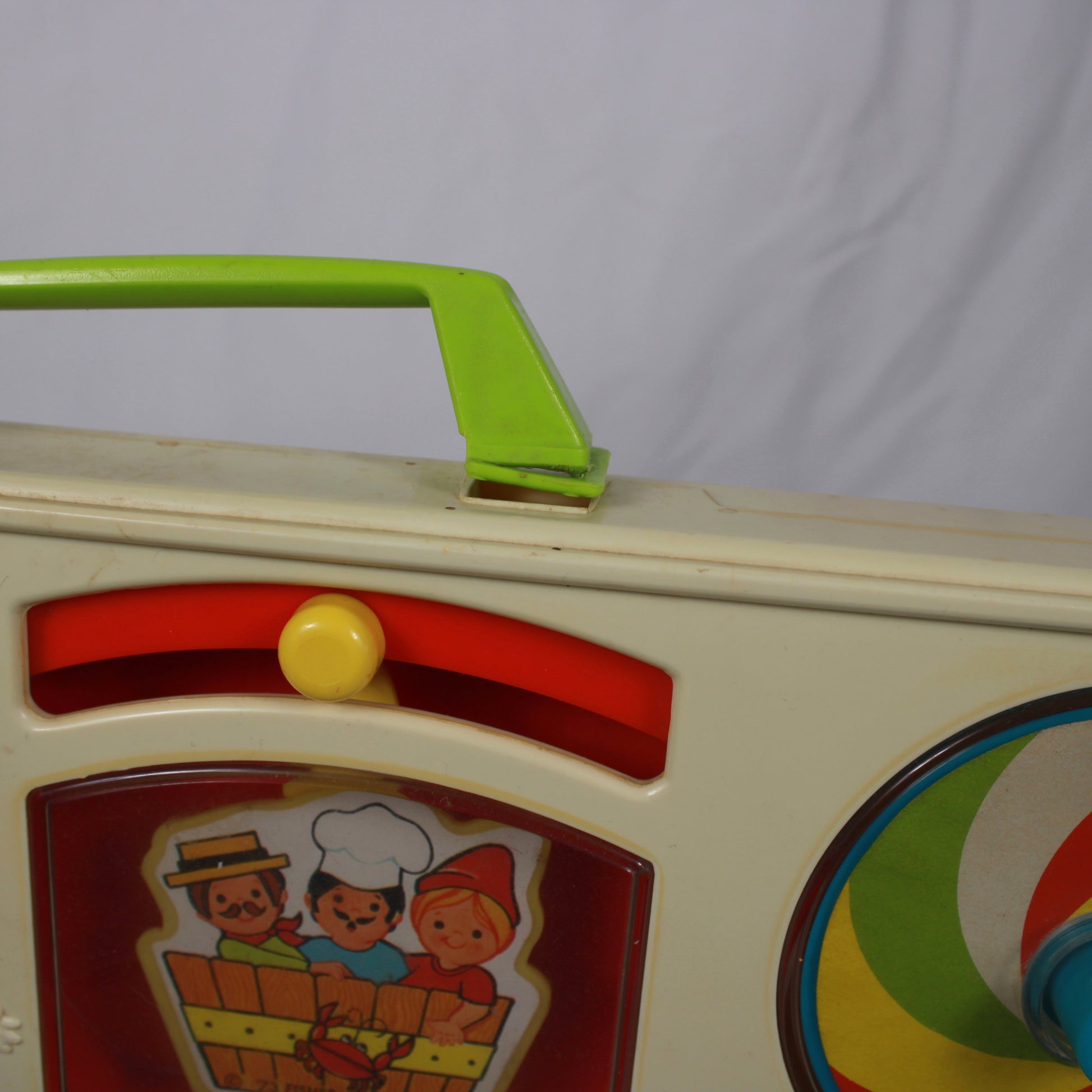 Toy with a green handle and colorful design on a white background