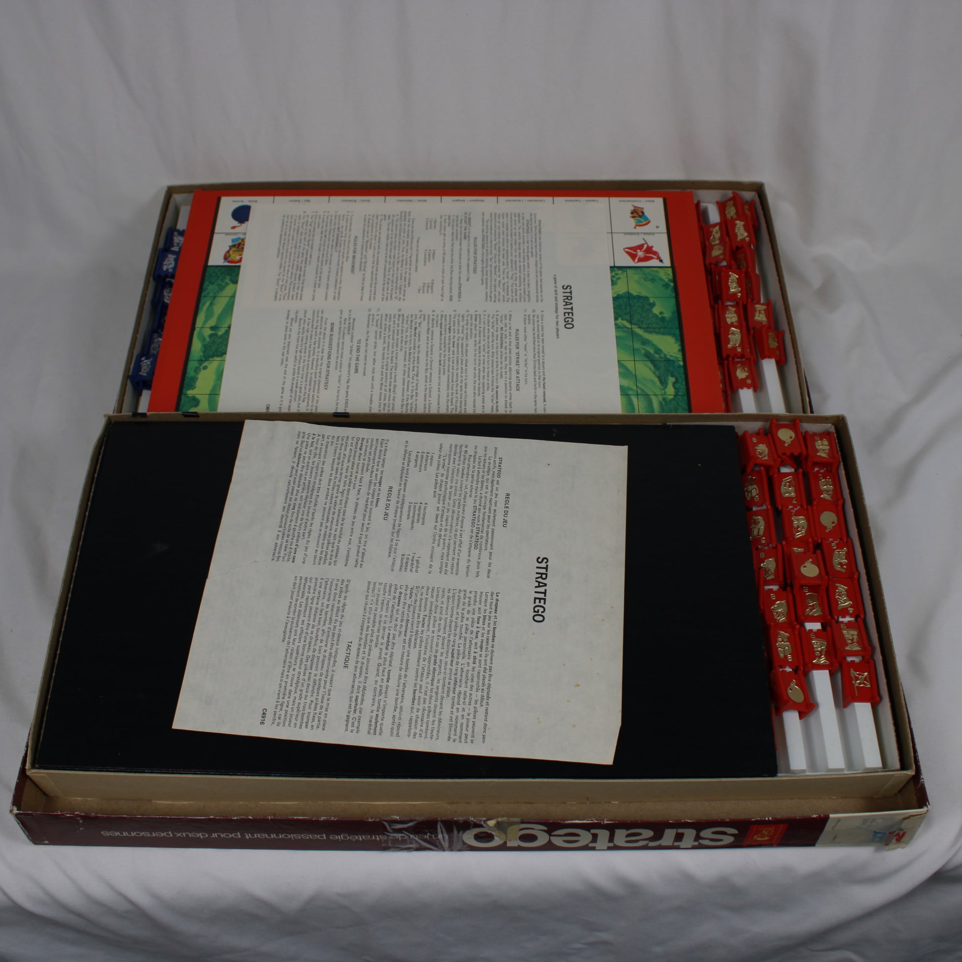 Stratego game box with strategy guide and pieces on a white background