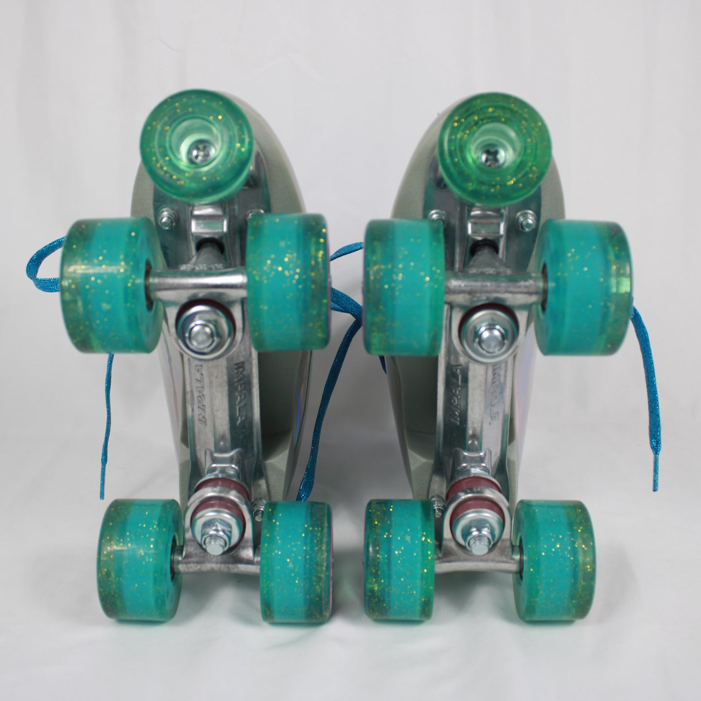 Pair of roller skates with teal wheels on a white background