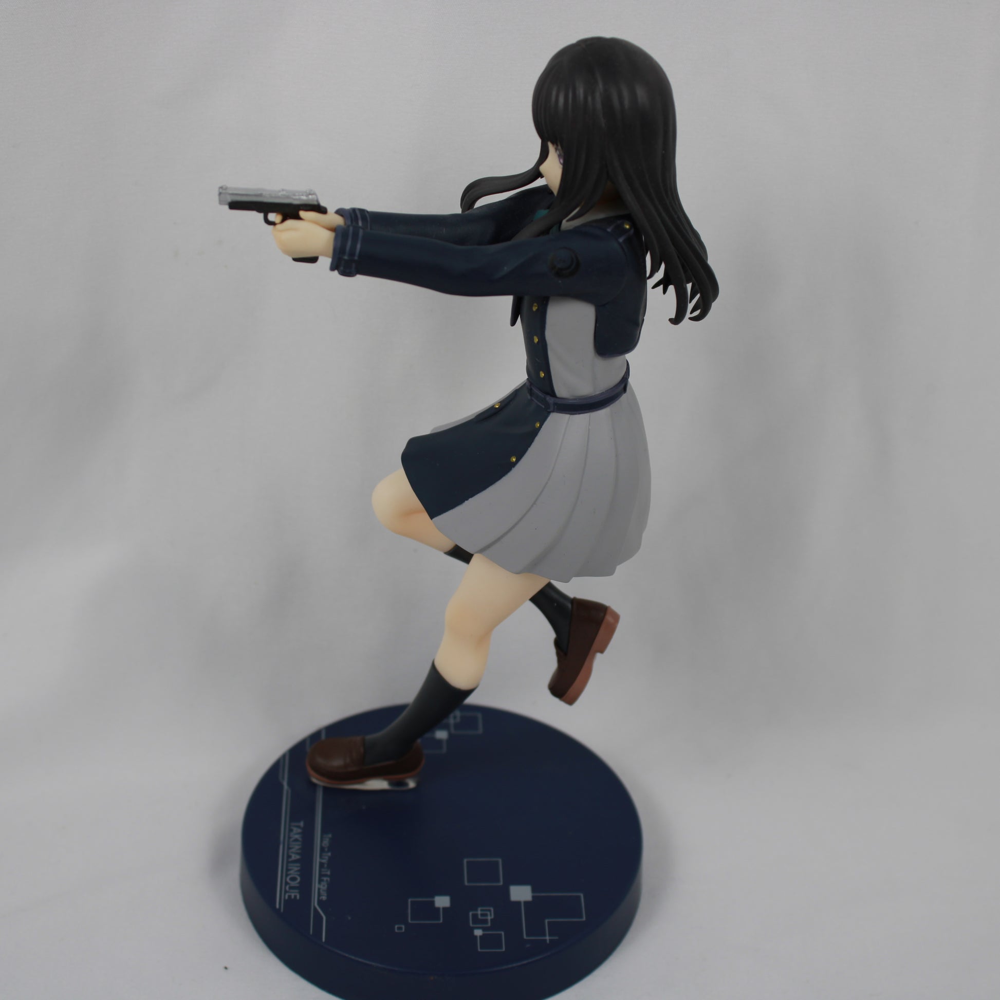 Figure of a character in a dynamic pose with a gun on a gray background