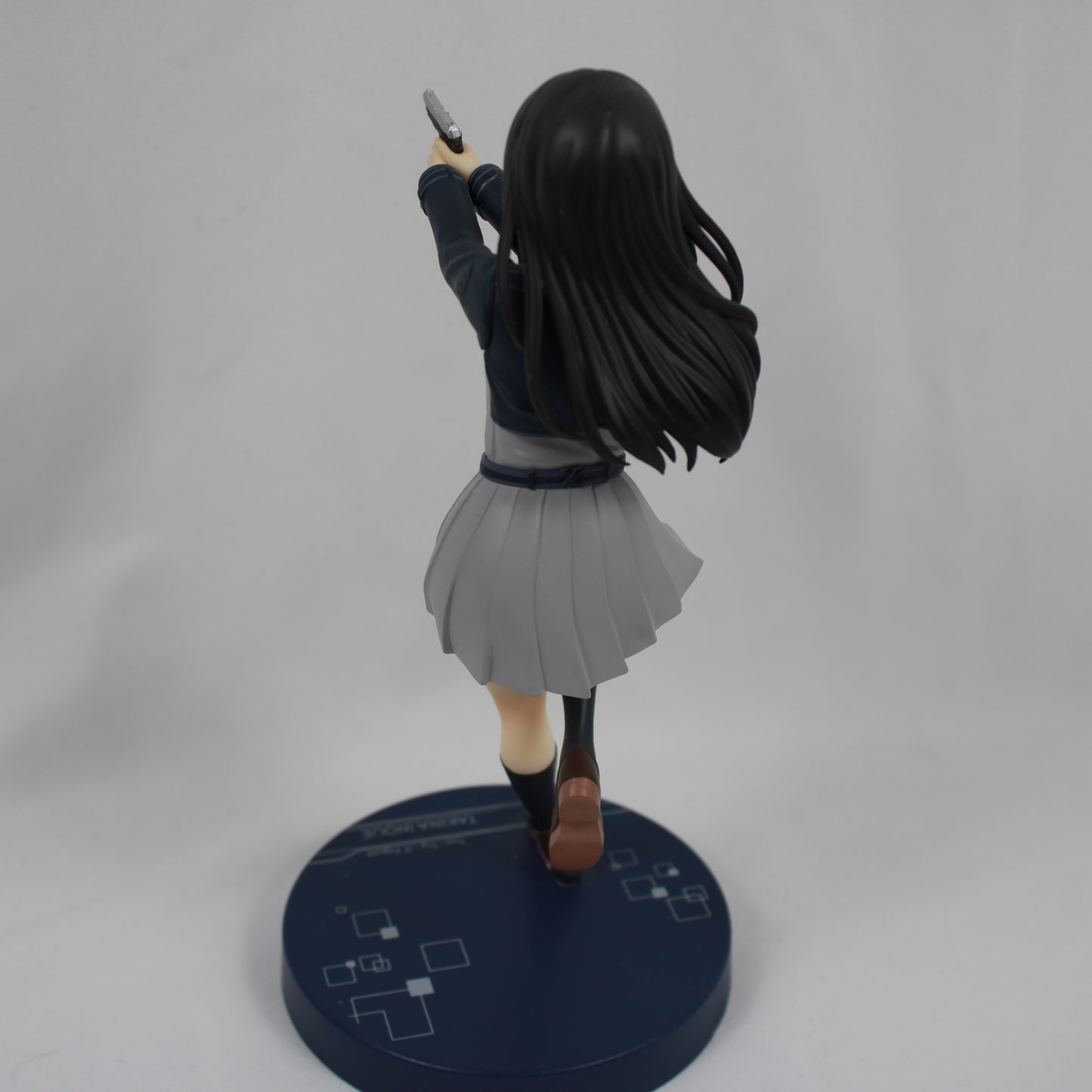 Figure of a character in a dynamic pose with a gun on a gray background