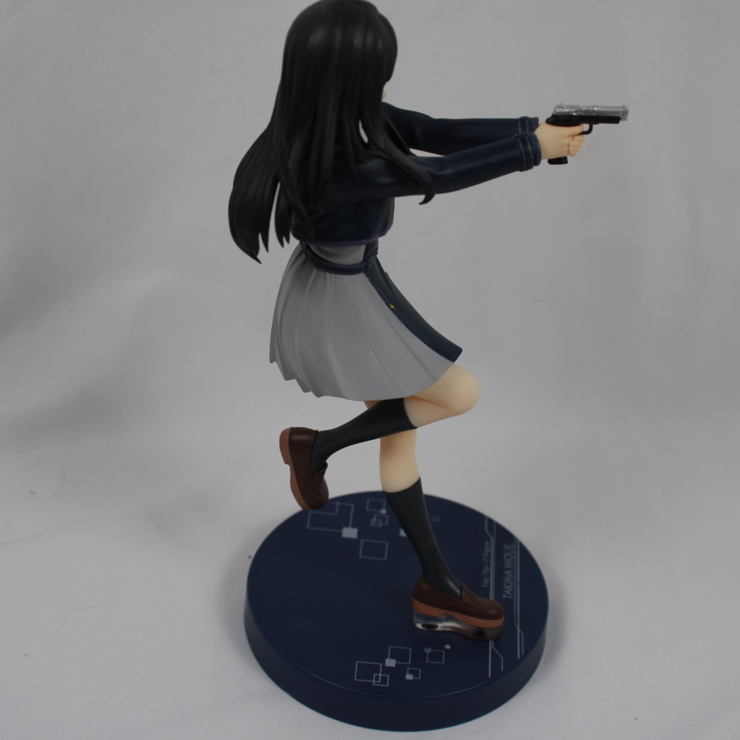 Figure of a character in a dynamic pose with a gun on a gray background