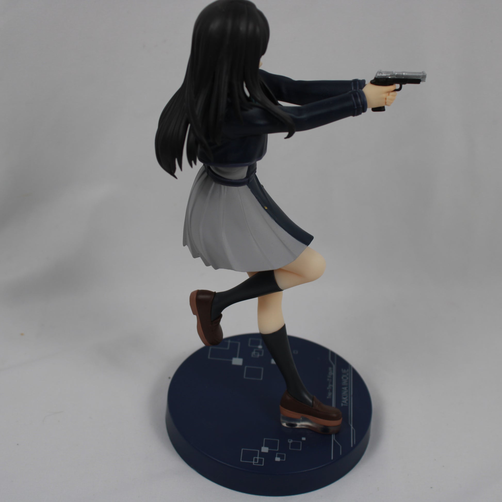 Figure of a character in a dynamic pose with a gun on a gray background