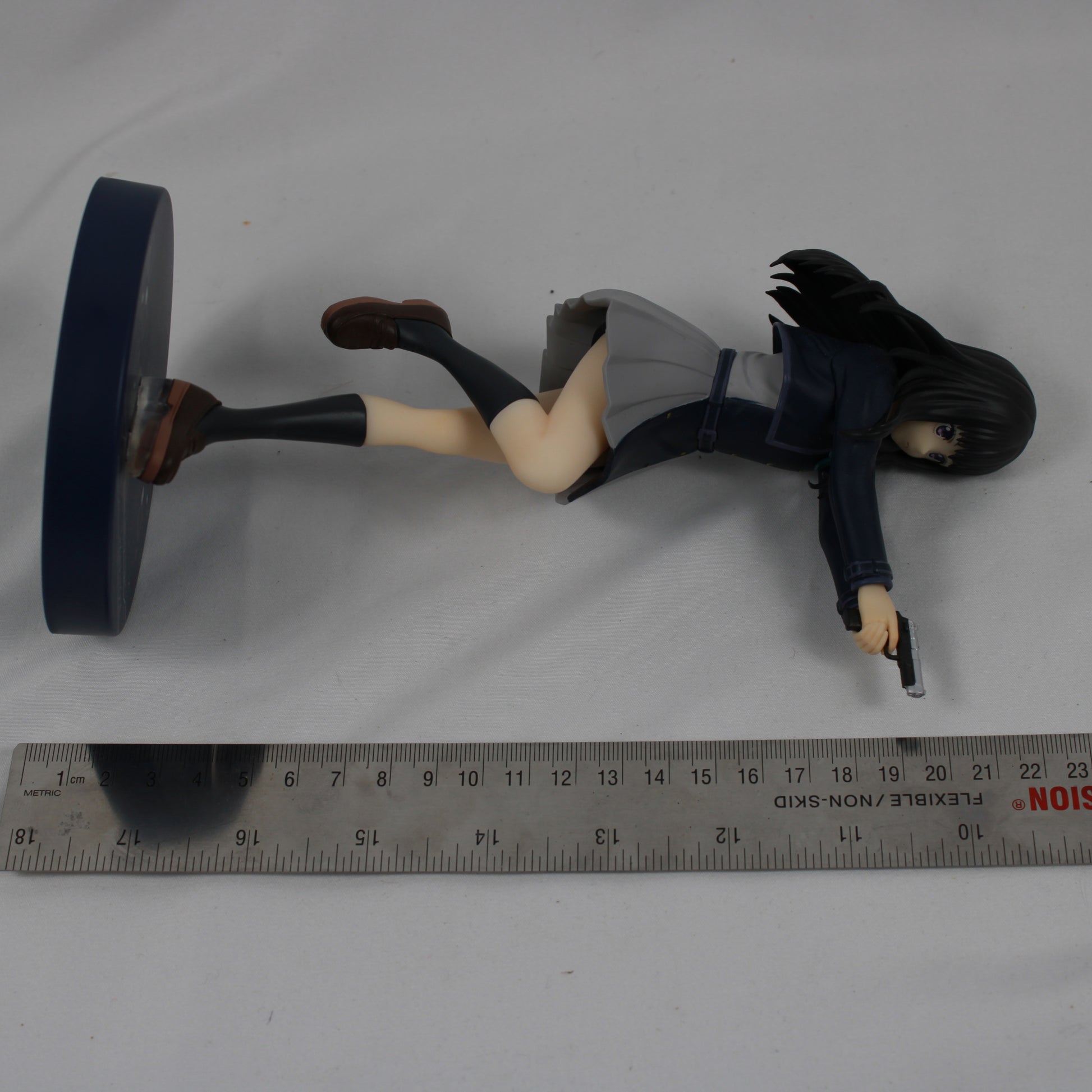 Figure of a character in a dynamic pose with a gun on a gray background