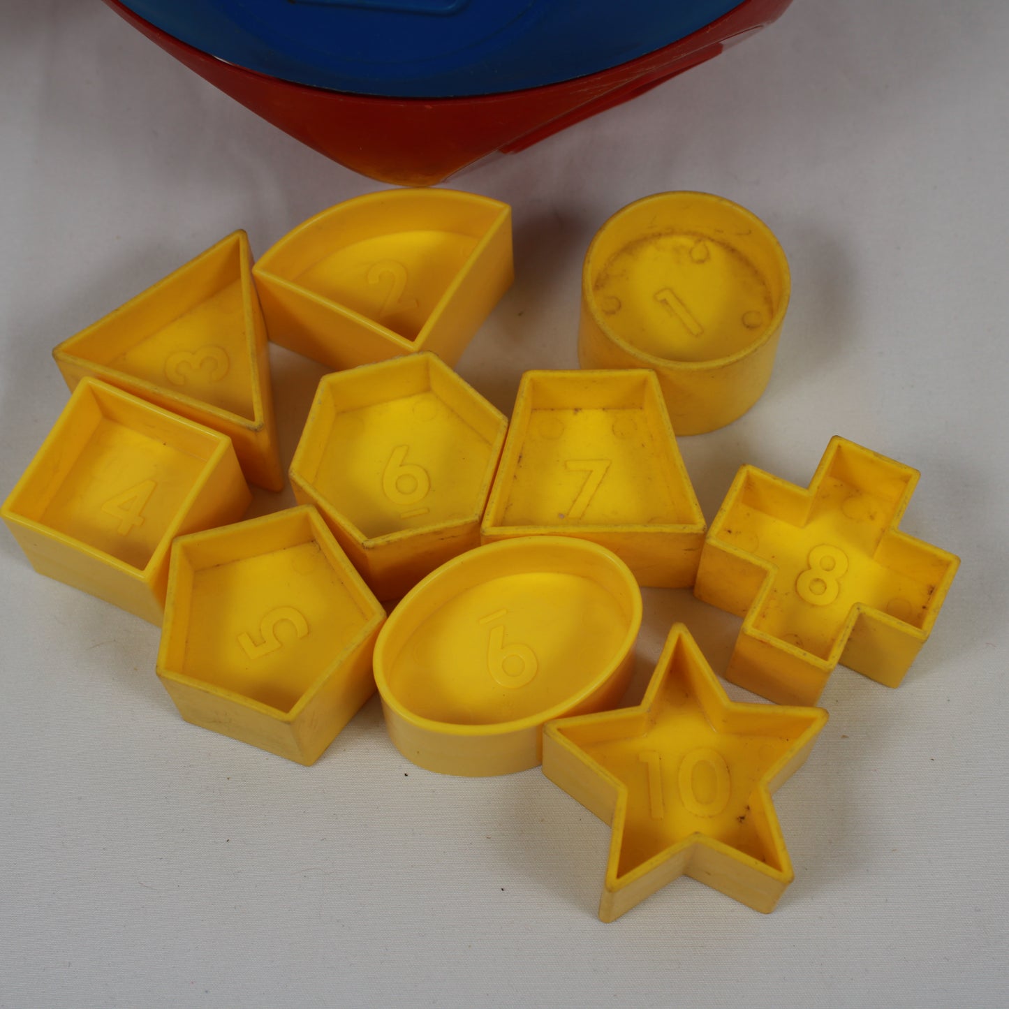 Yellow plastic molds with various shapes on a white background