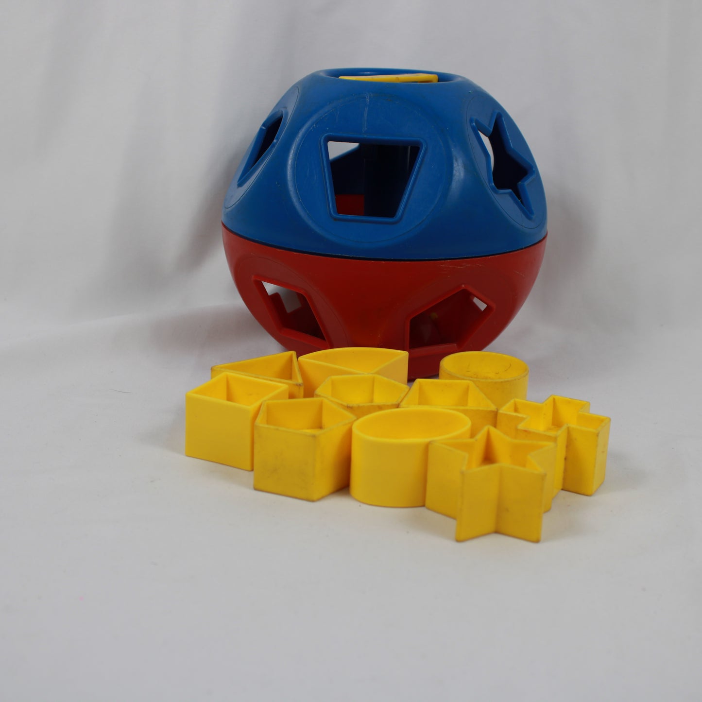 Red and blue puzzle ball with yellow blocks on a white background