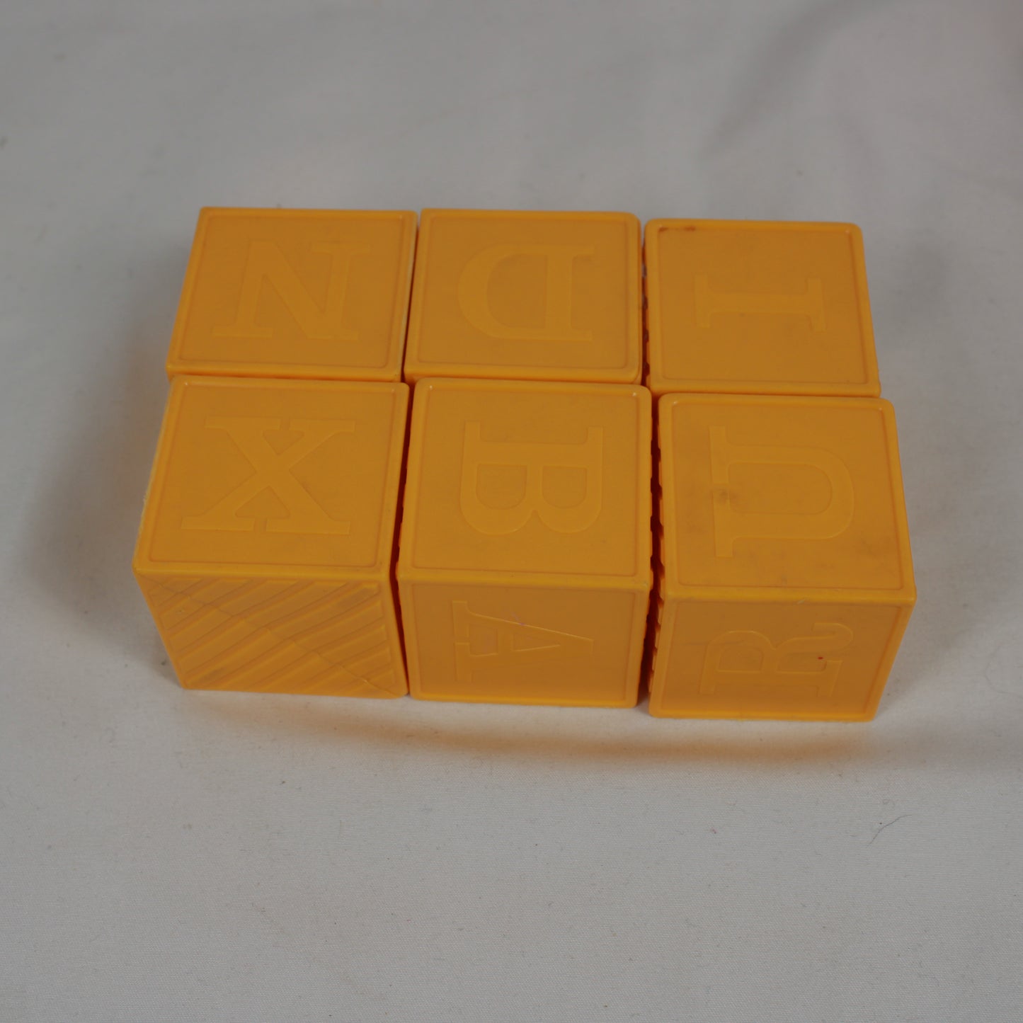 Six yellow blocks with lettering on a white background