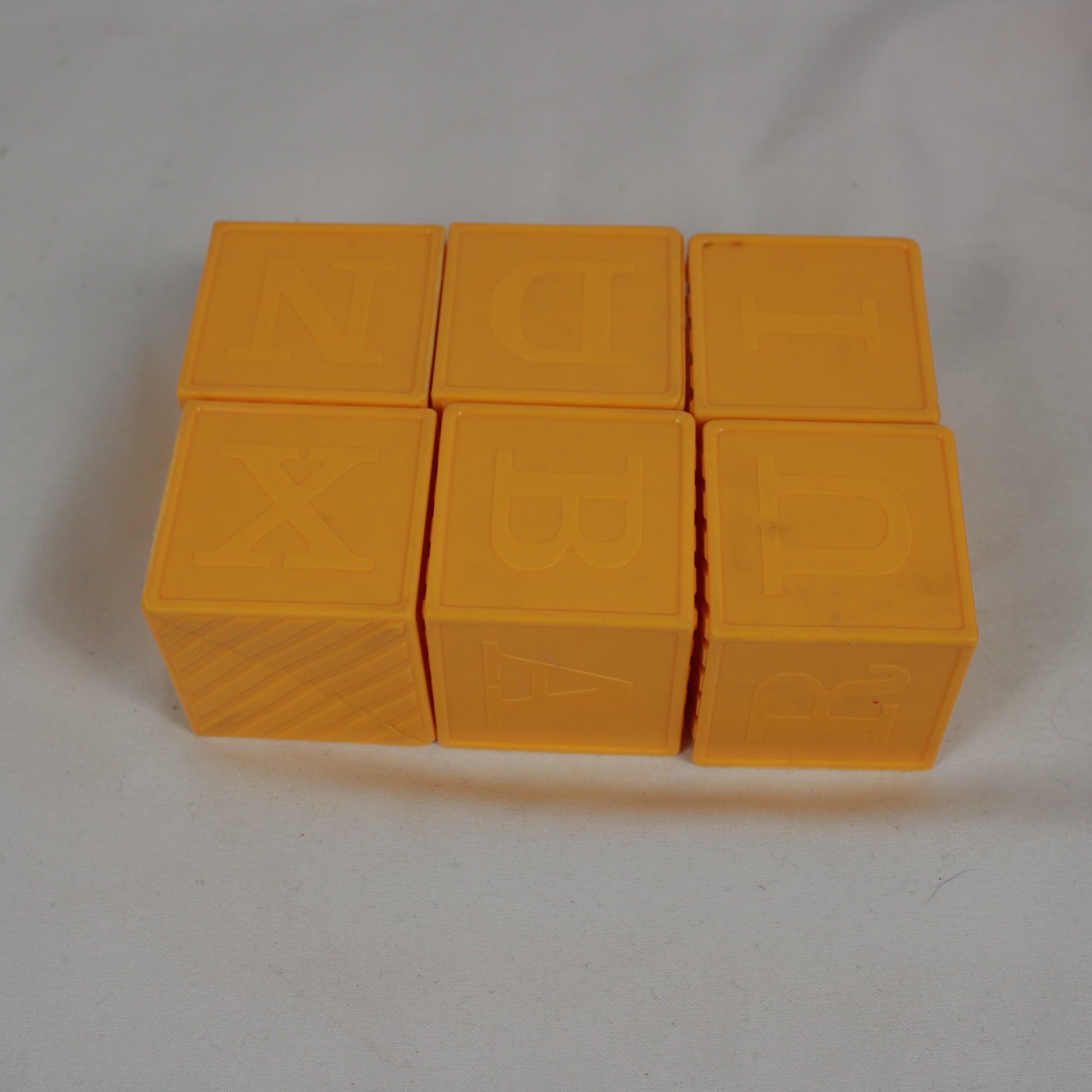 Six yellow blocks with lettering on a white background