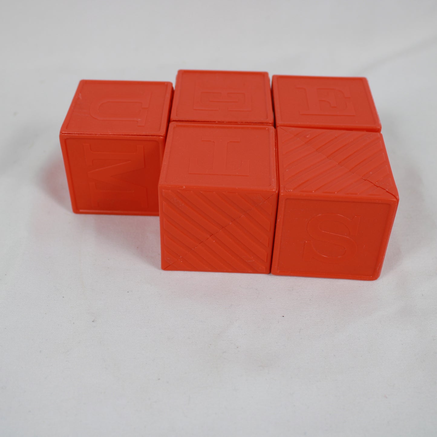 Four orange building blocks stacked on a white background