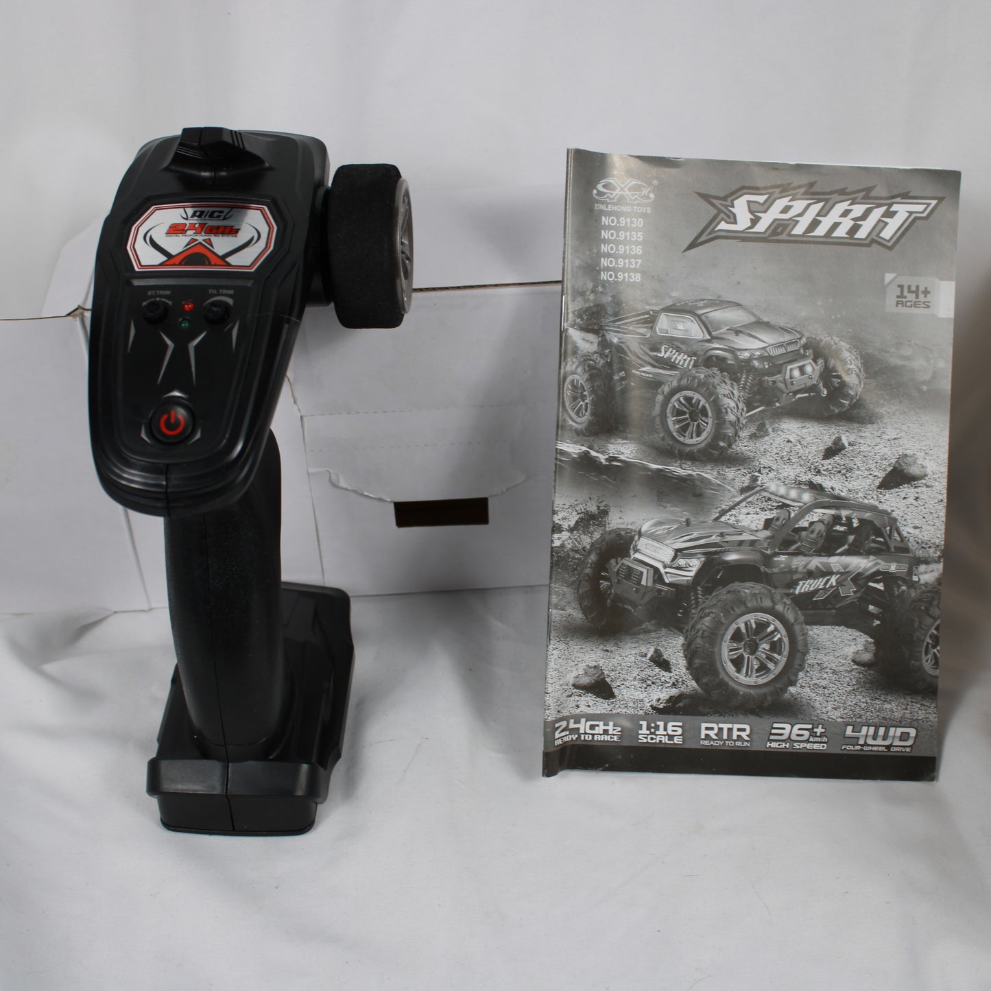 Black remote control with a box featuring a toy truck design on a white background