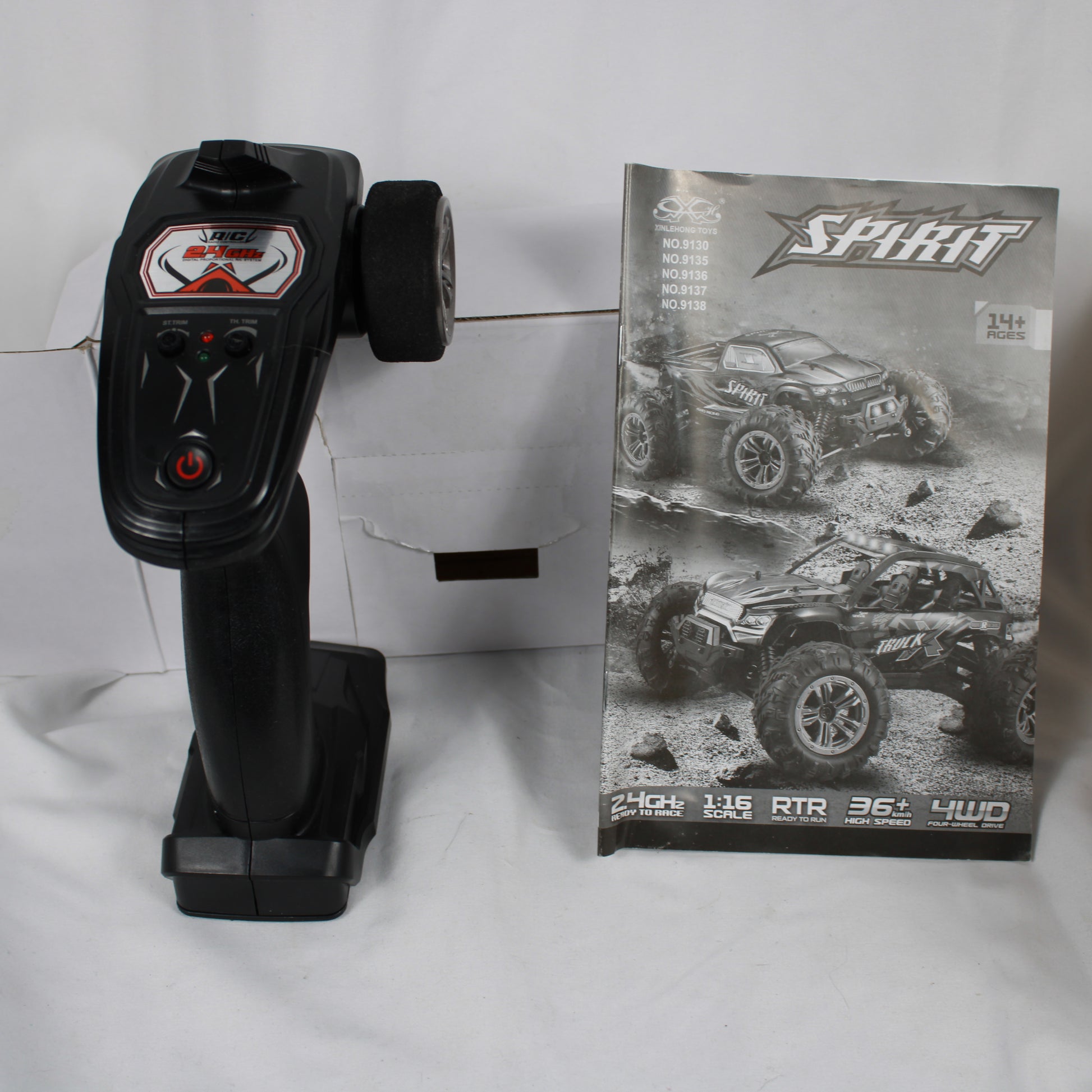 Black remote control with a box featuring a toy truck design on a white background
