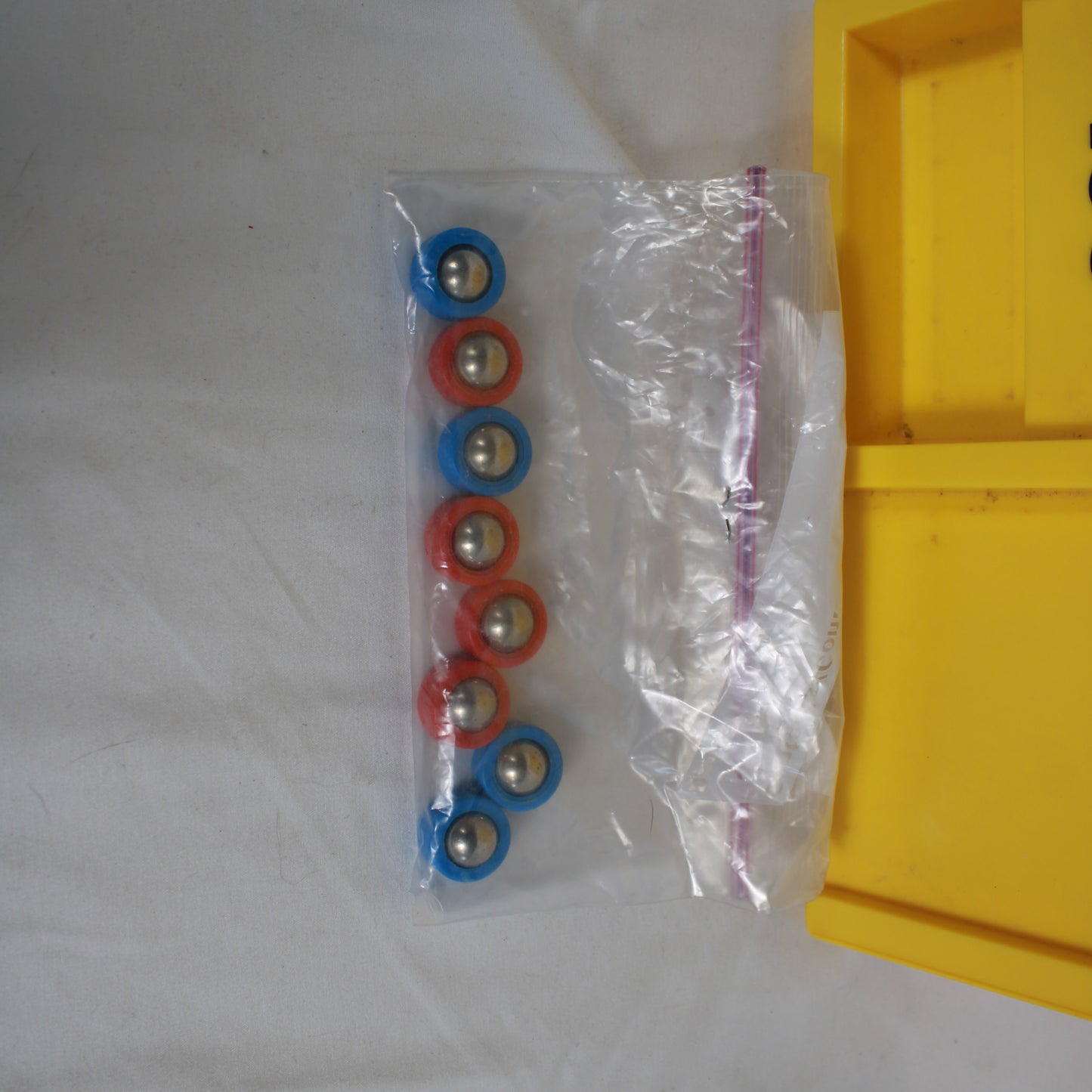 Packaged set of colorful bearings on a white surface with a yellow object partially visible.