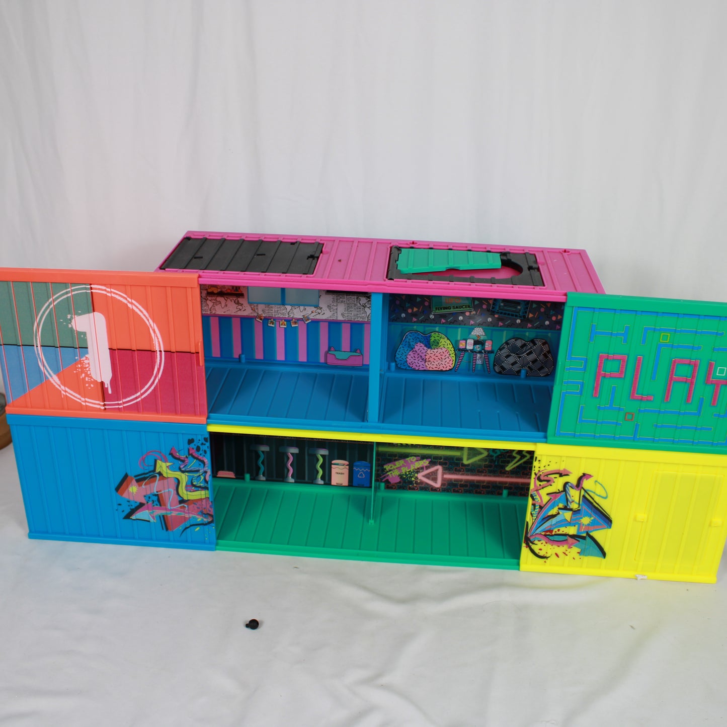 Colorful toy playset with various compartments on a white background