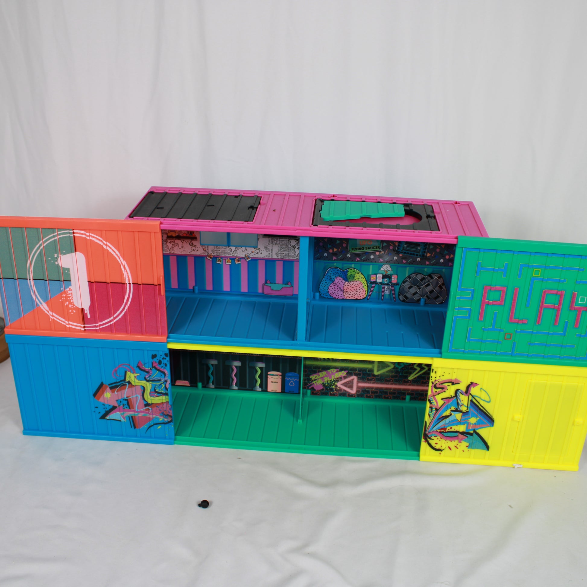 Colorful toy playset with various compartments on a white background