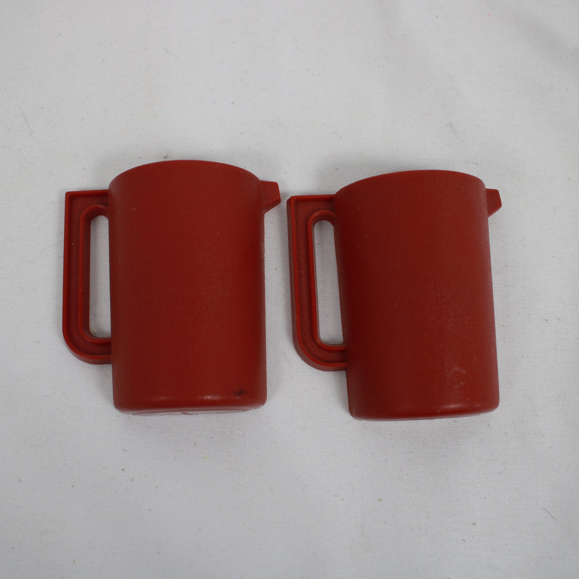 Two red plastic mugs on a light gray background