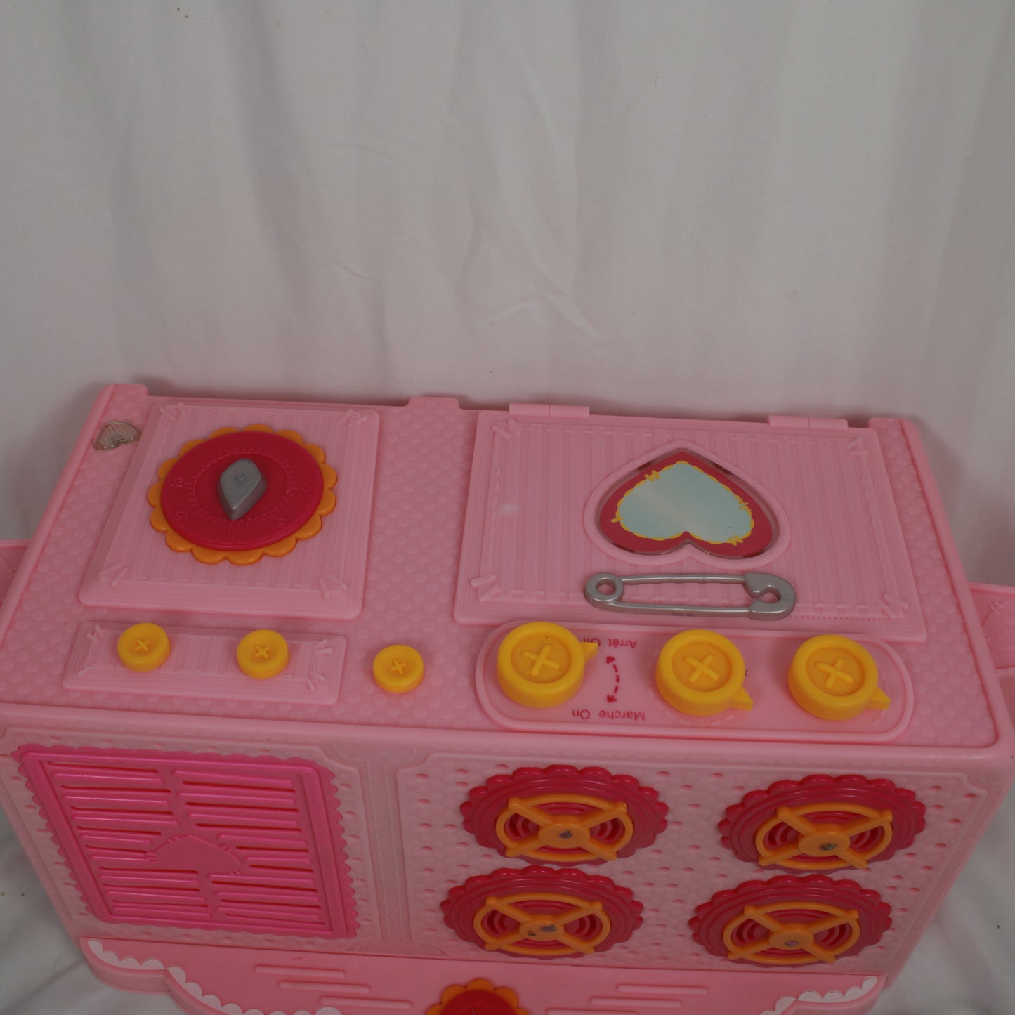 Pink toy kitchen set with various components on a white background