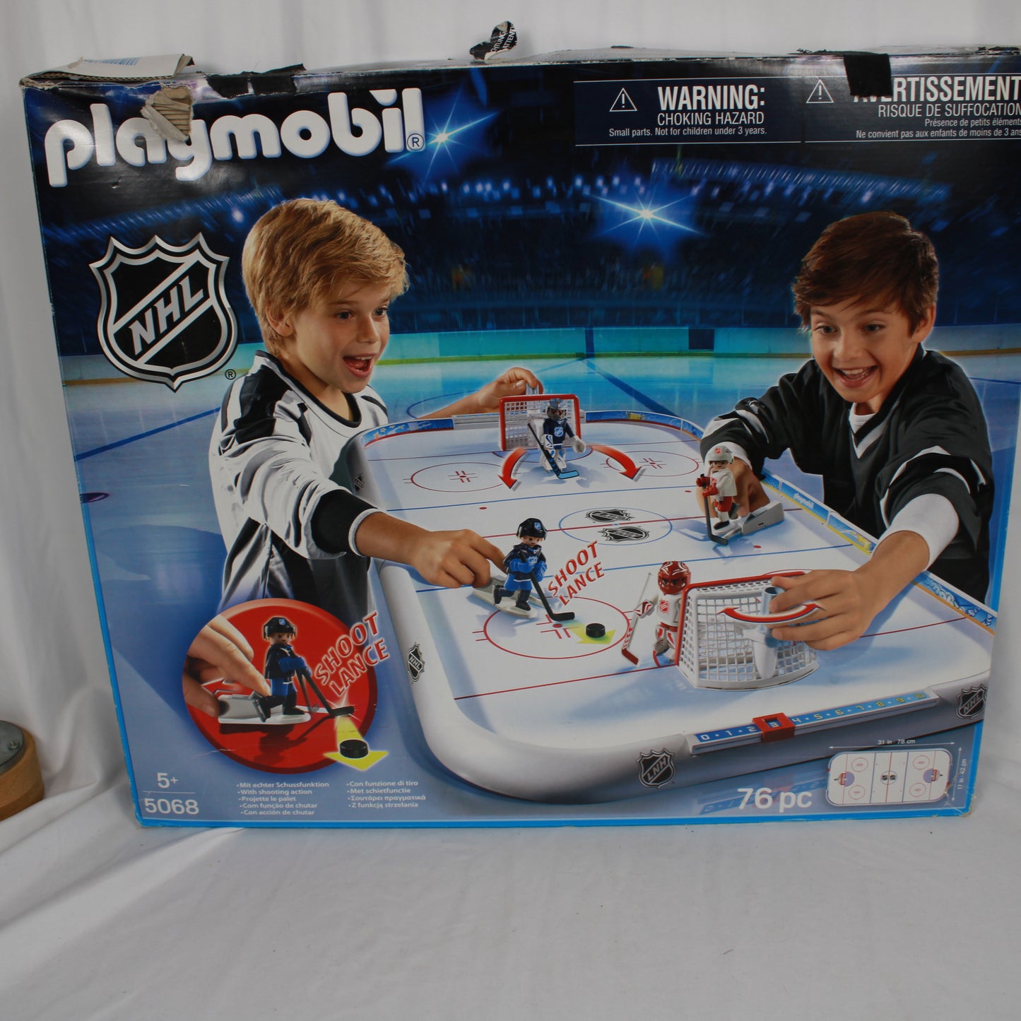 Playmobil NHL hockey set packaging with two children playing on a table.