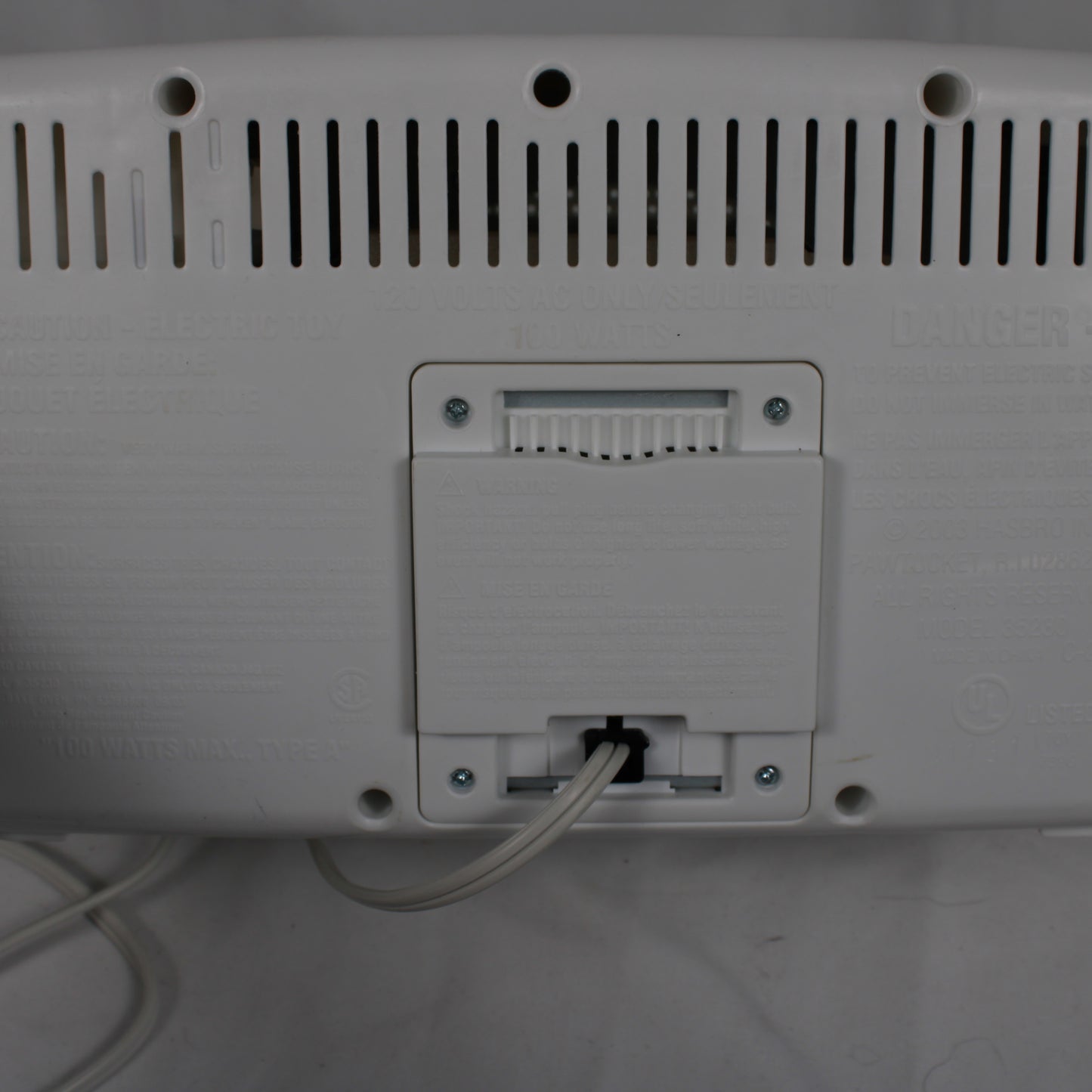 Back view of a electronic device with ports and cables on a white surface