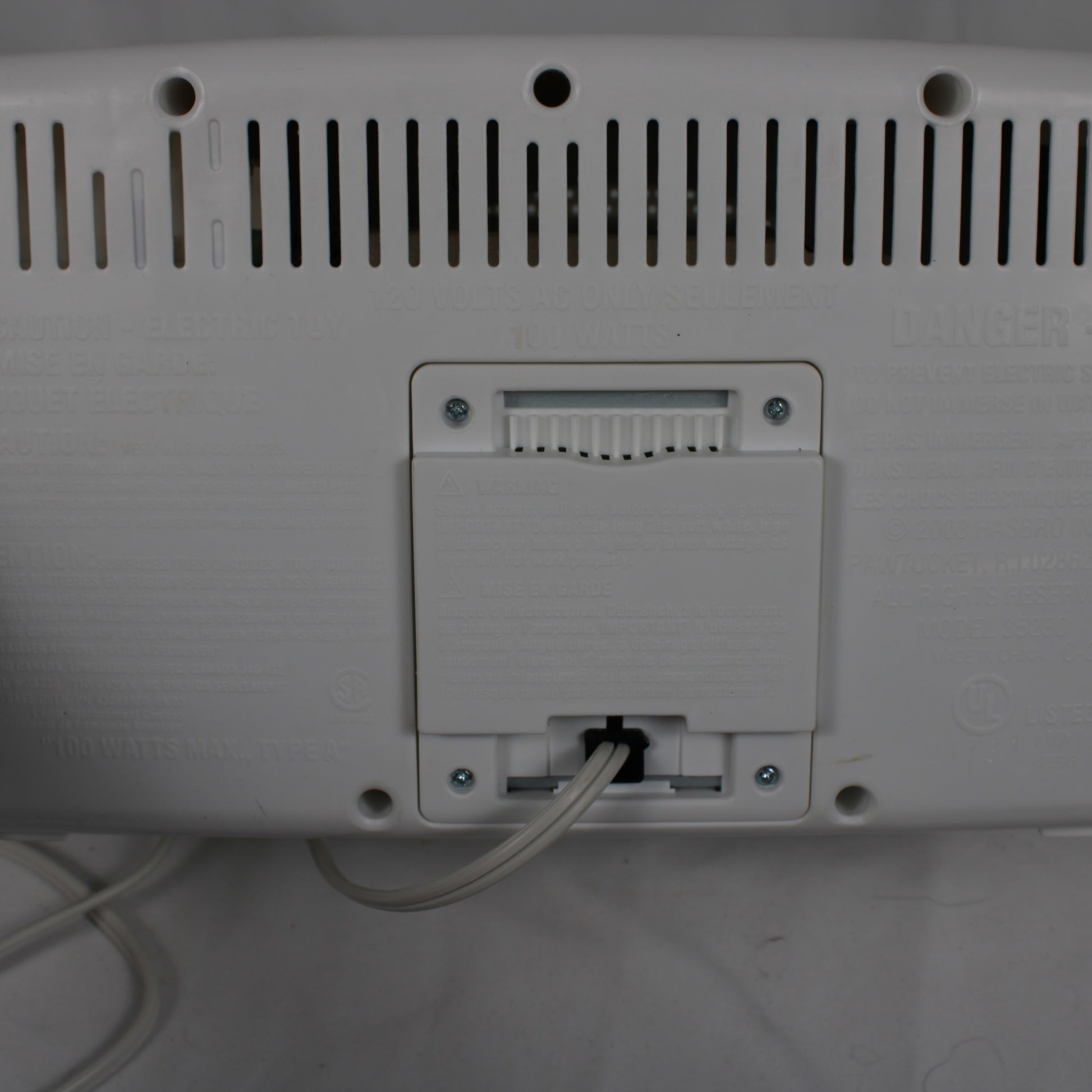 Back view of a electronic device with ports and cables on a white surface