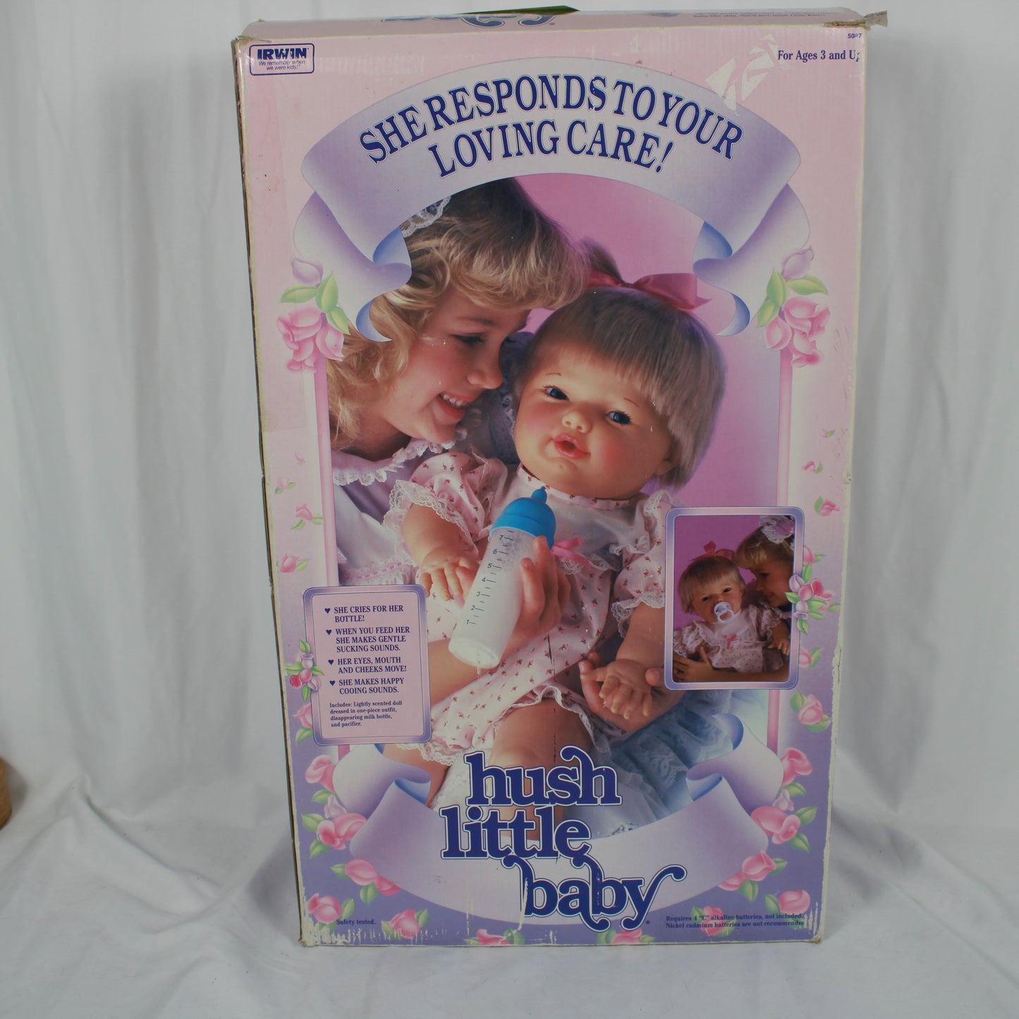 Box for a hush little baby doll with a child holding the doll and text on the packaging.