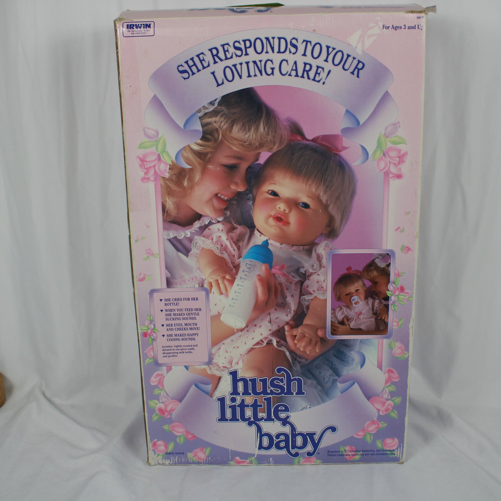 Box for a hush little baby doll with a child holding the doll and text on the packaging.