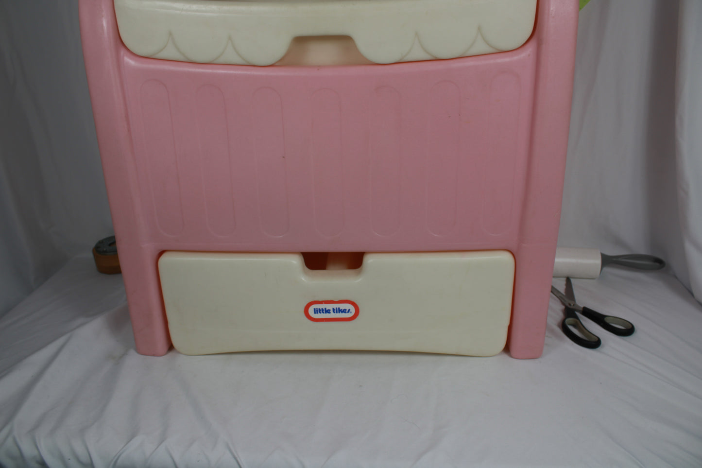 Pink plastic step stool with a white base on a white background