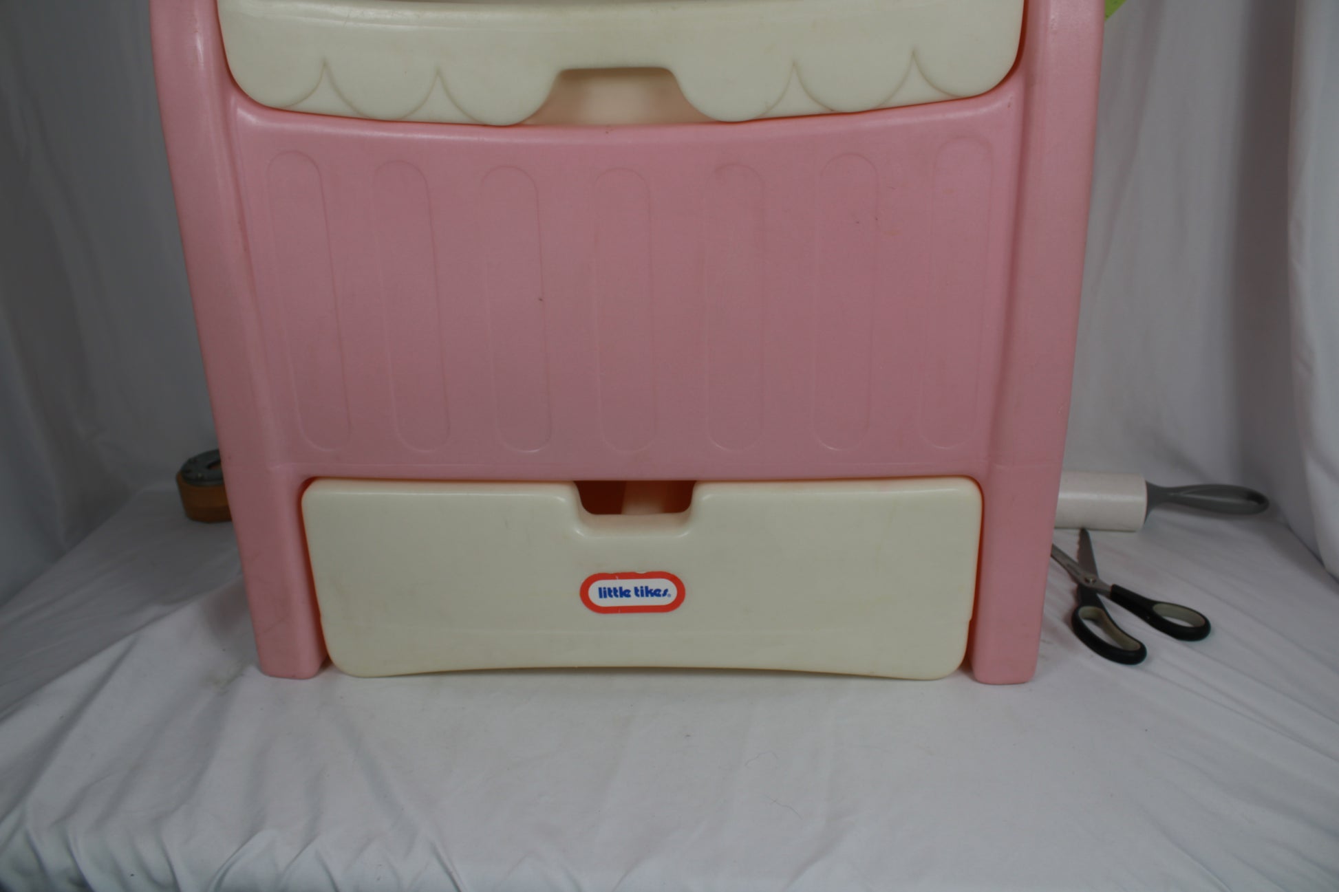 Pink plastic step stool with a white base on a white background