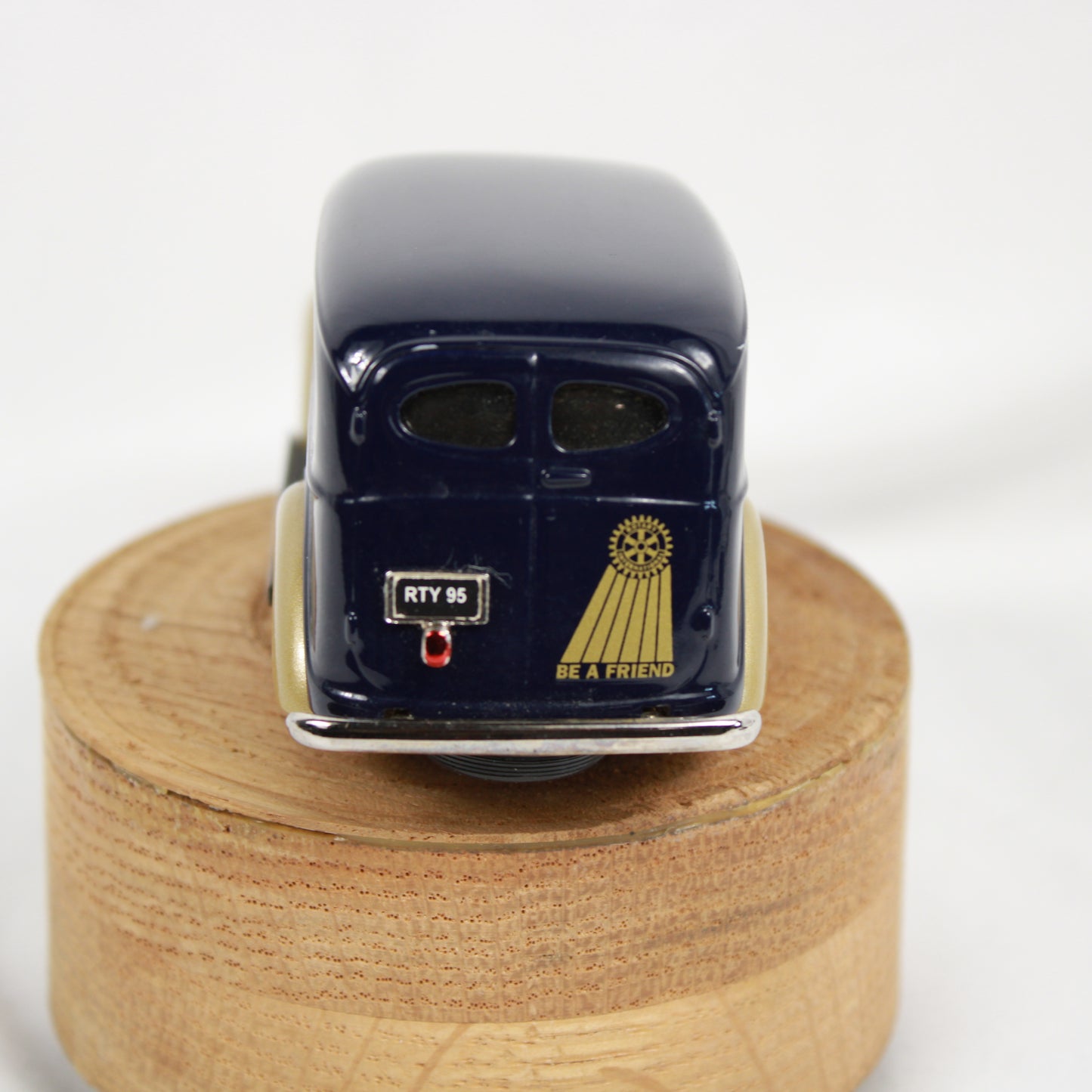 Model car on a wooden stand with a white background