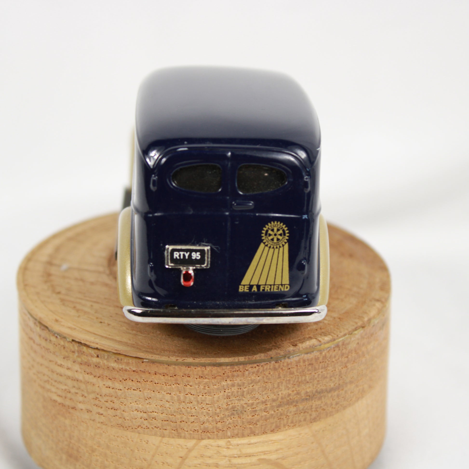 Model car on a wooden stand with a white background