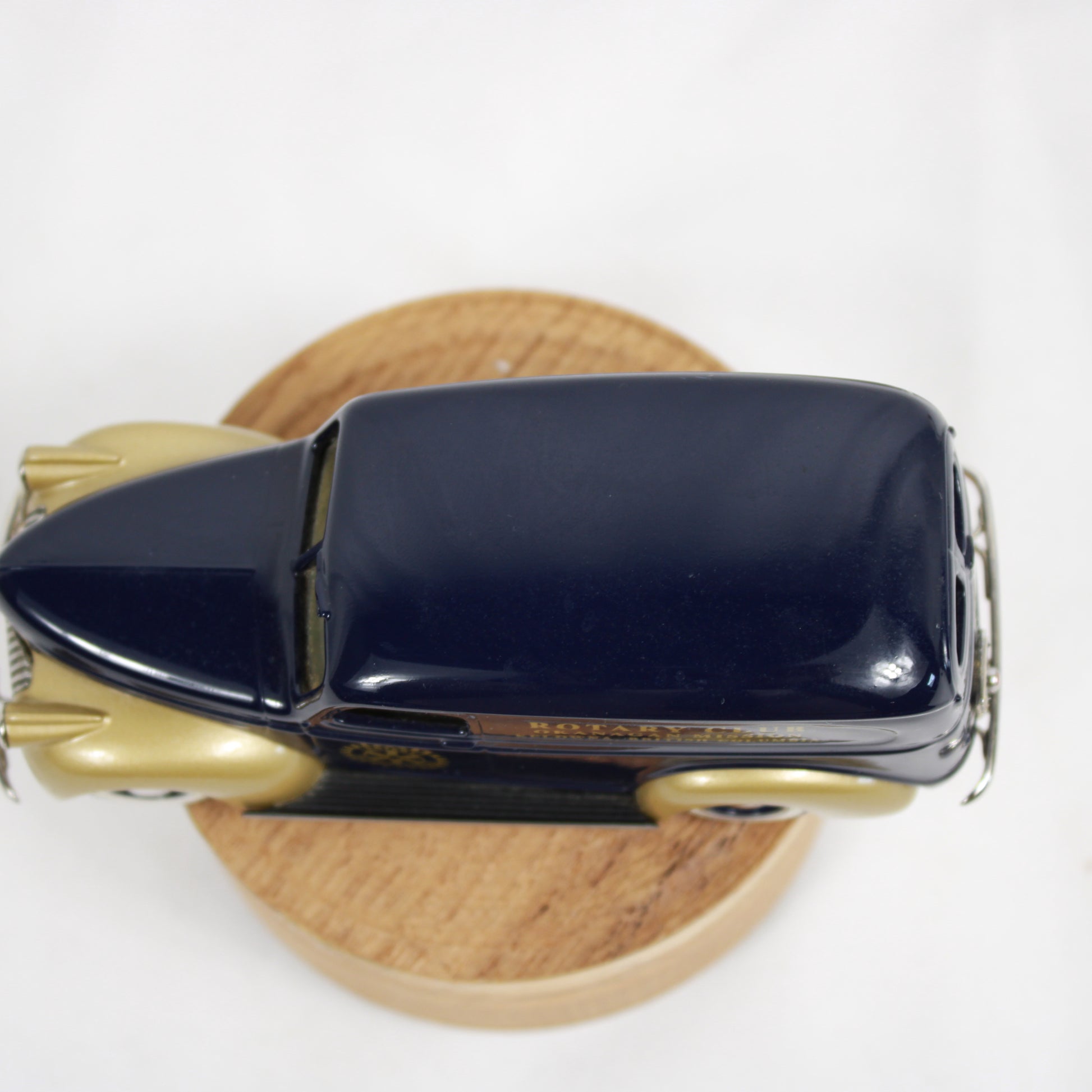 Model of a vintage car with Rotary Club branding on a wooden base