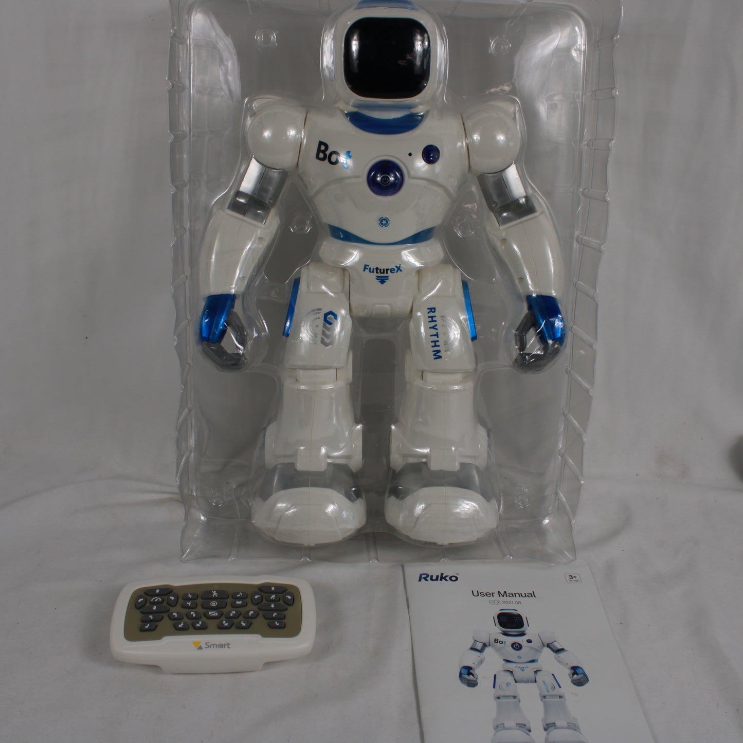 Toy robot in packaging with remote control and manual on a white background